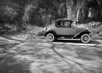 A vintage car parked on a quiet road, labeled with information about its make, model, and history.