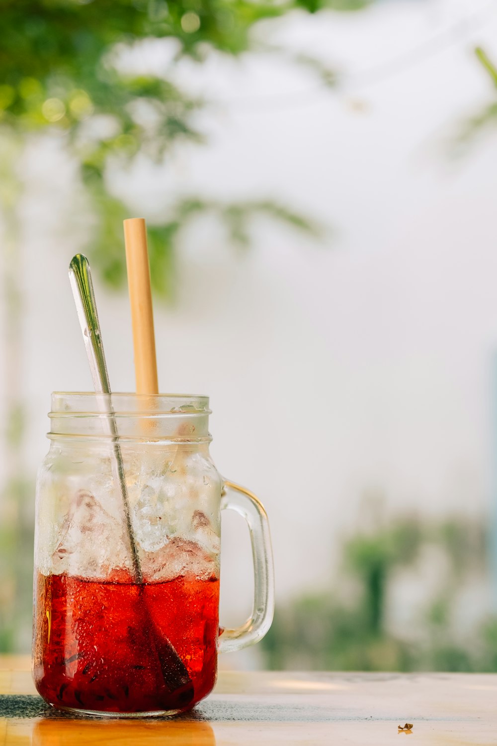 a mason jar filled with liquid and two straws