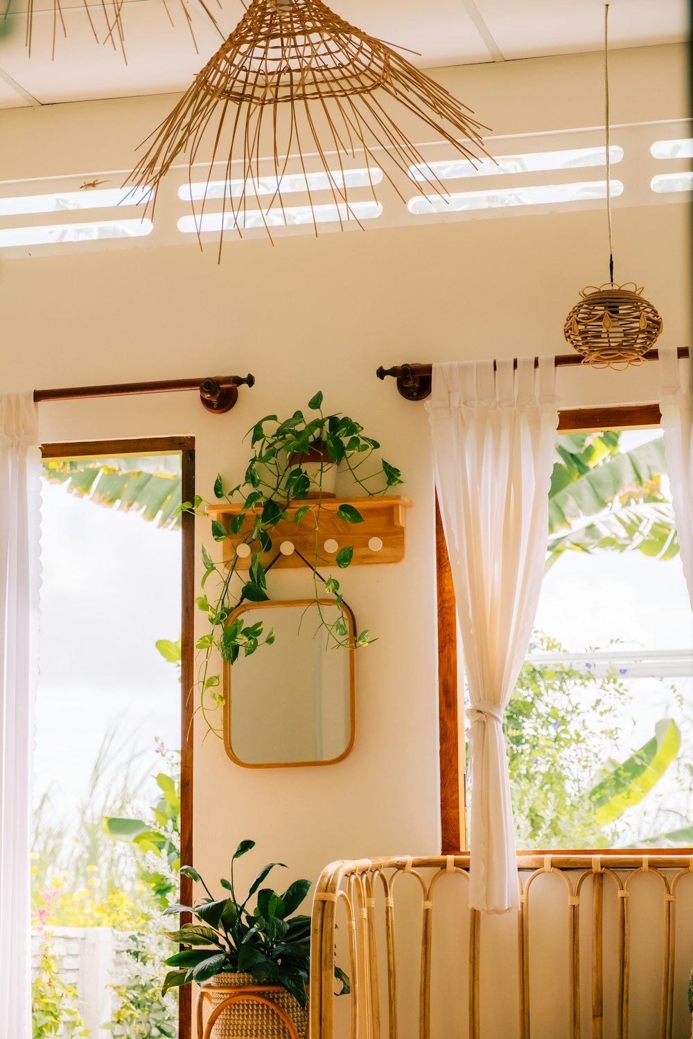 a living room with a wicker chair and potted plants