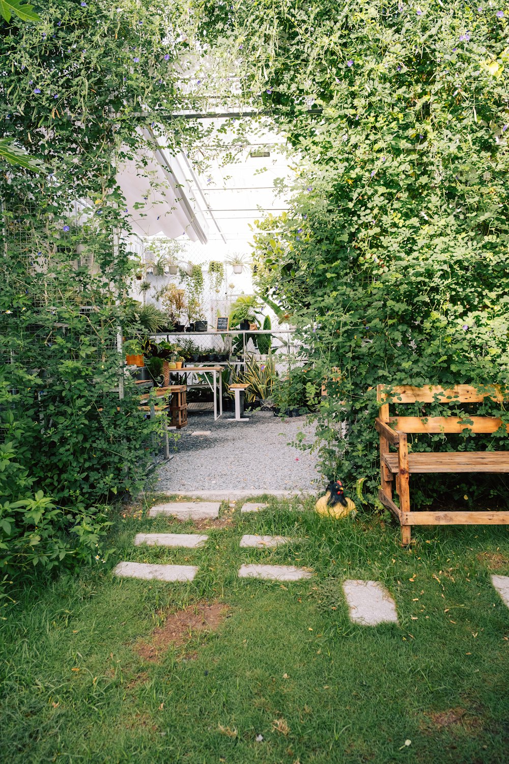 a wooden bench sitting in the middle of a lush green yard