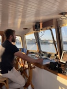 a man sitting at the helm of a boat