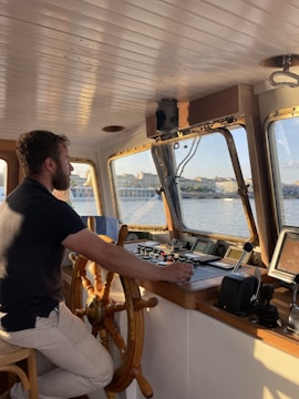a man sitting at the helm of a boat