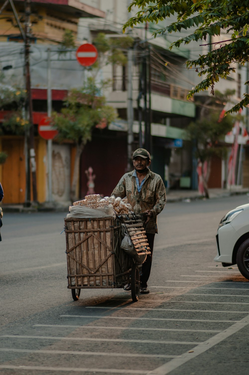 a man pushing a cart with food in it down a street