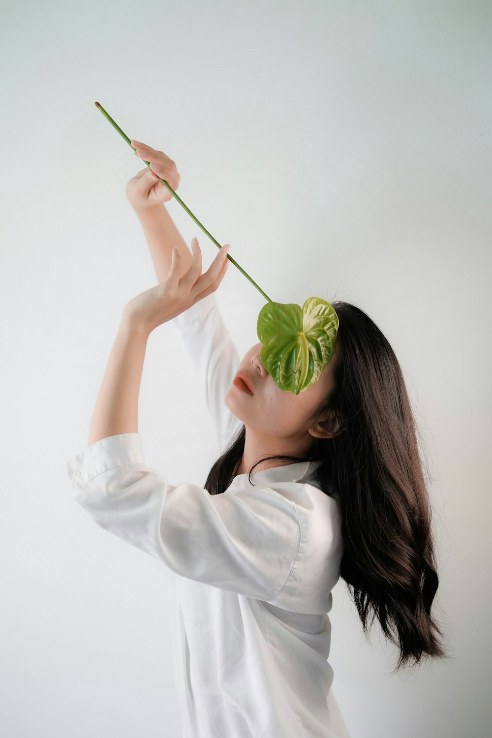 a woman holding a plant in her hand