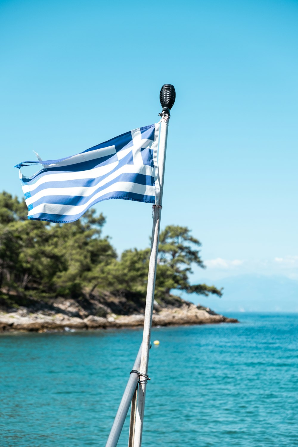 a blue and white flag on a boat in the water