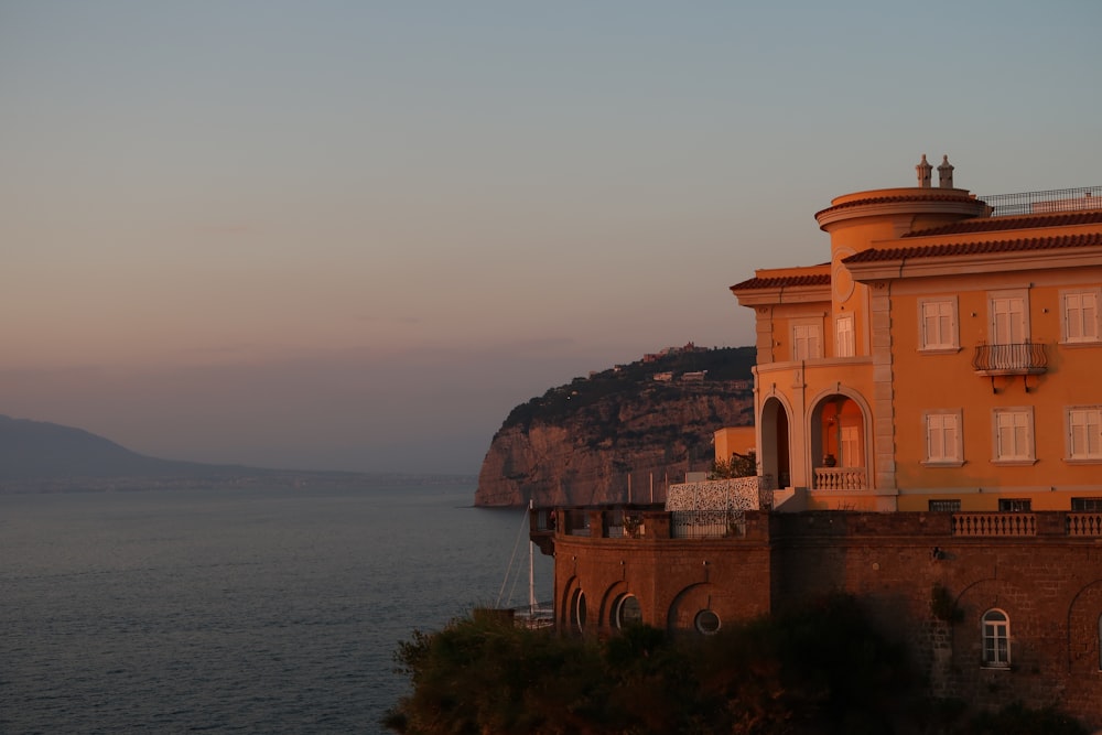 a building sitting on top of a cliff next to the ocean