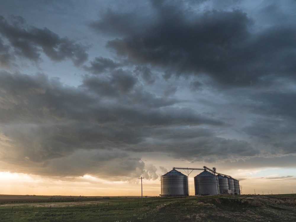 a couple of silos sitting on top of a lush green field