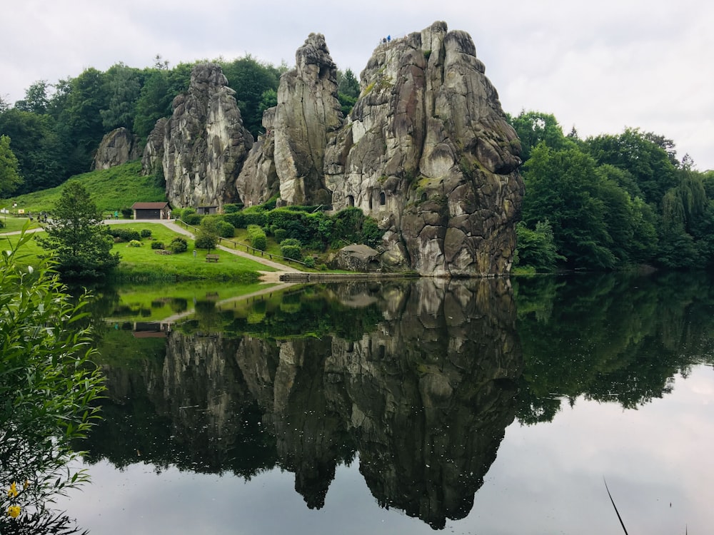 a lake surrounded by large rocks in the middle of a forest