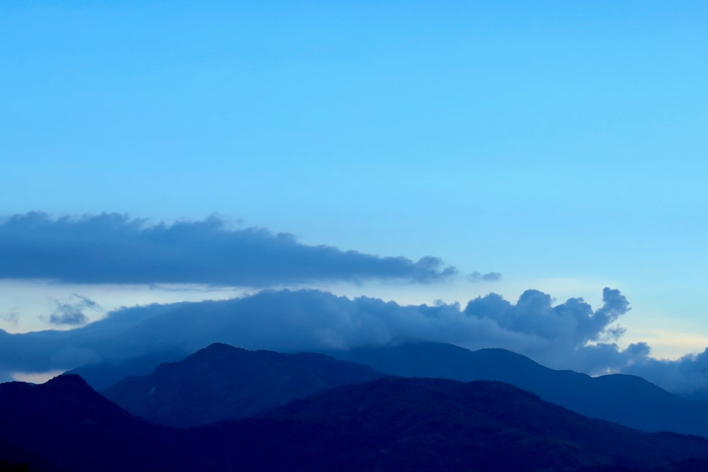 a plane flying in the sky over a mountain range