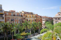 a row of buildings with palm trees in front of them