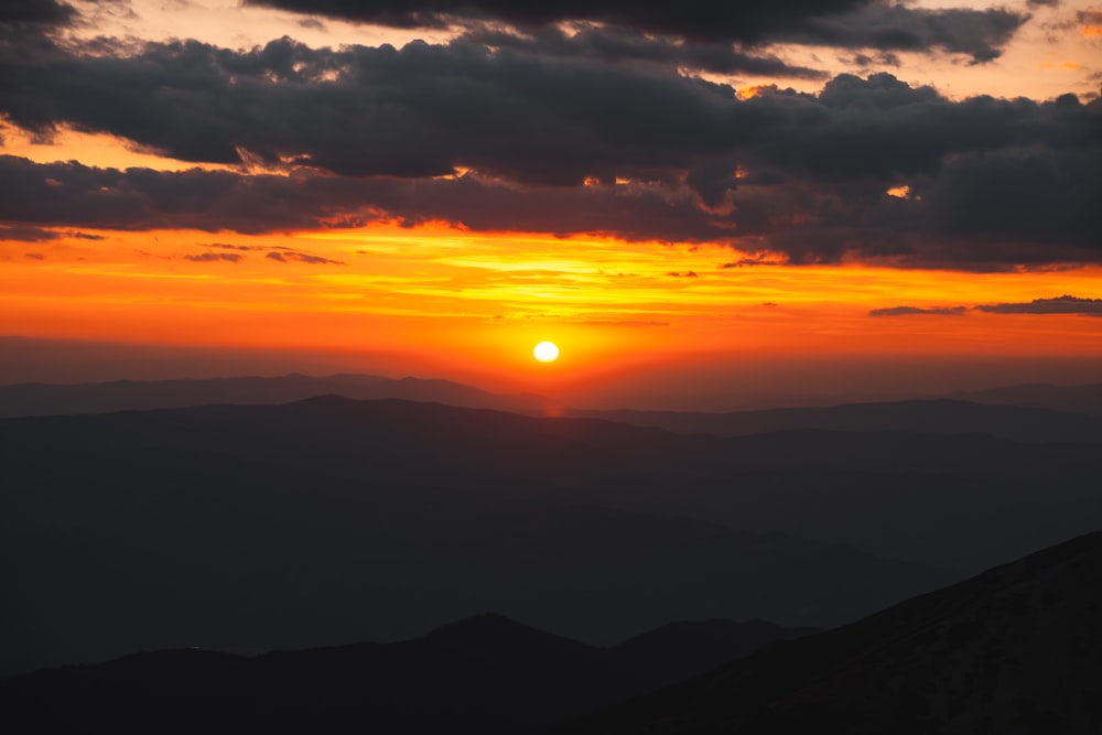 o sol está se pondo sobre uma cordilheira