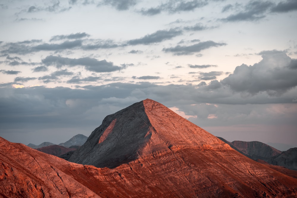 a mountain range with a few clouds in the sky