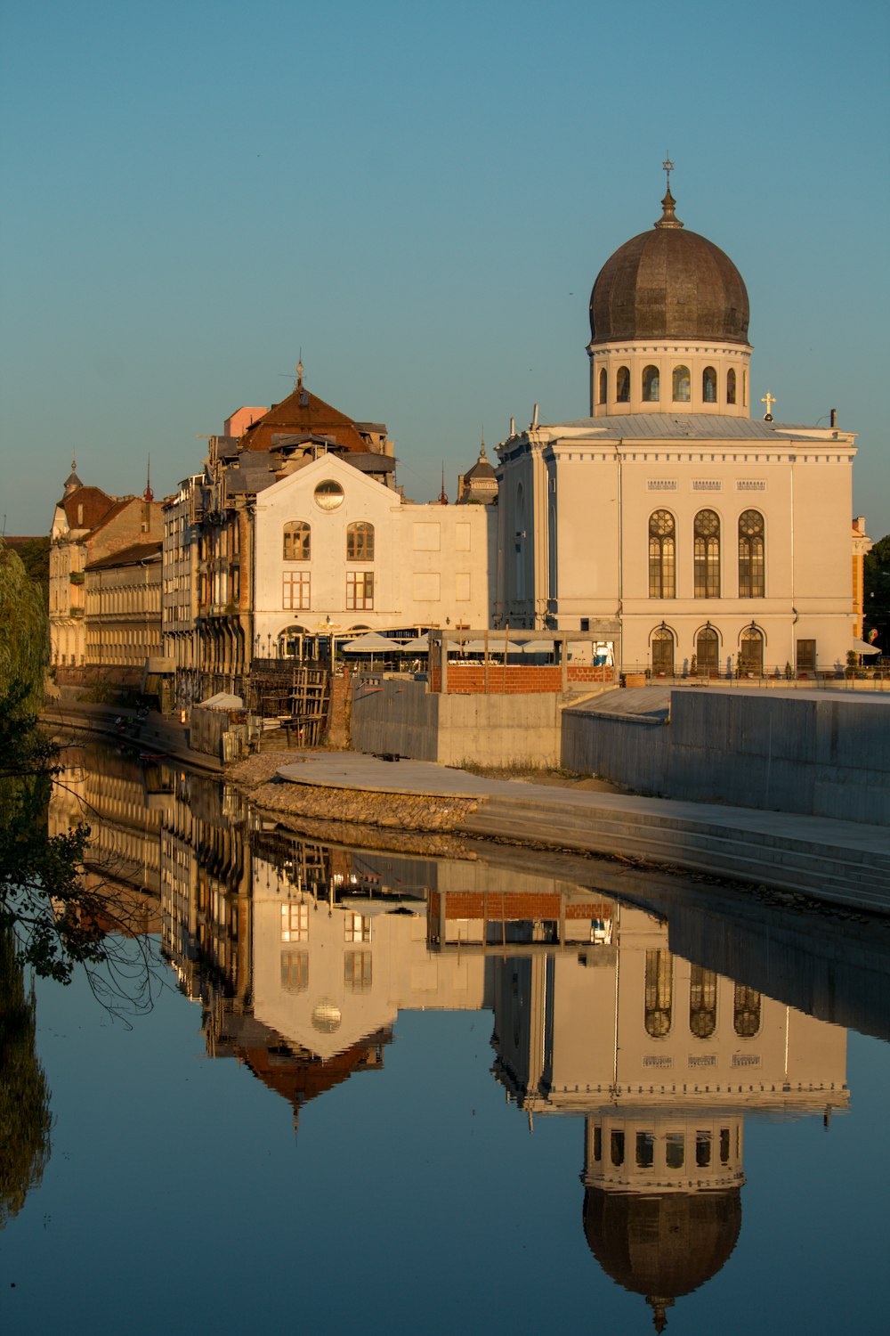 a building with a dome is reflected in a body of water