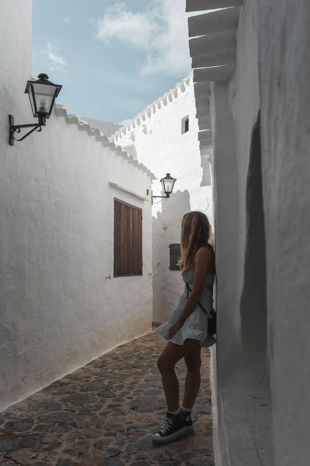 a woman standing in a narrow alley way