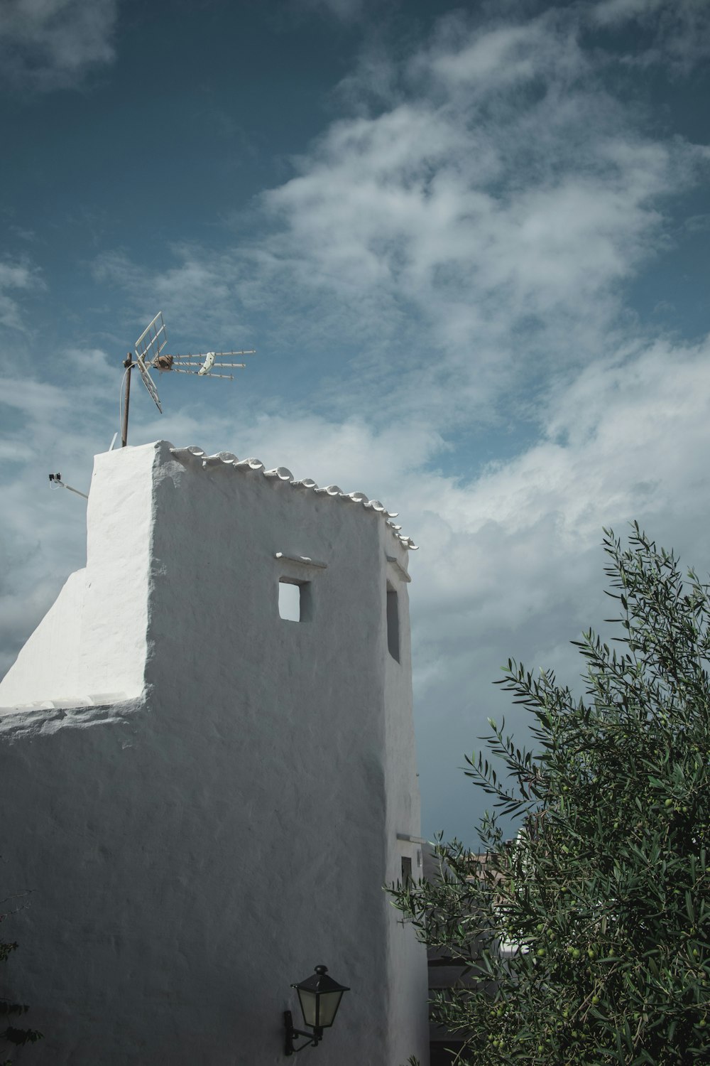 a white building with a weather vane on top of it