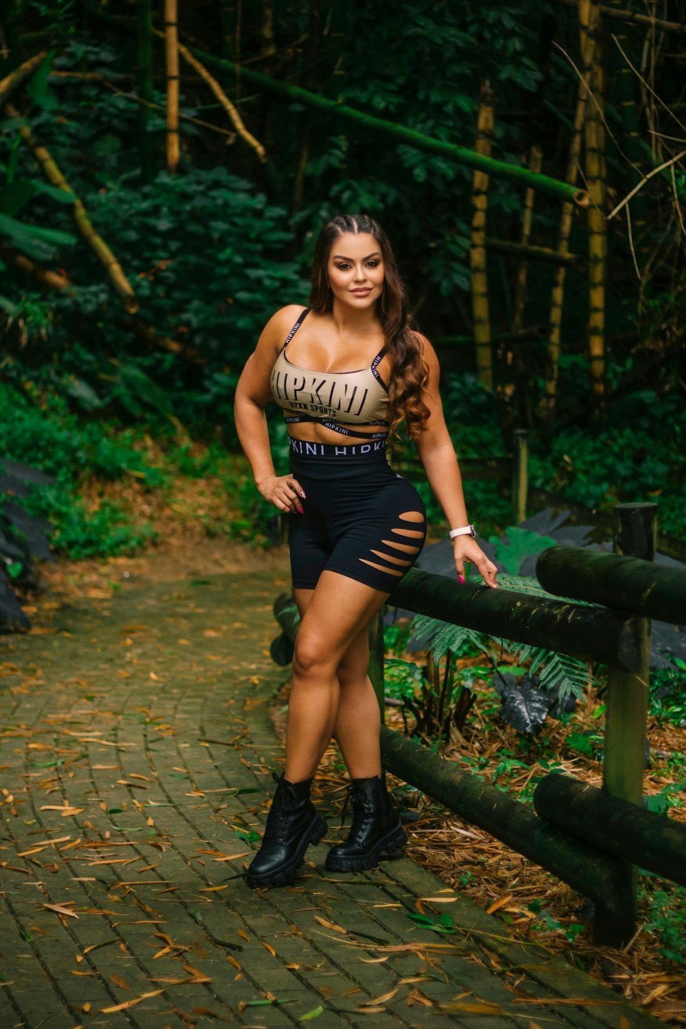 a woman posing on a bridge in the woods