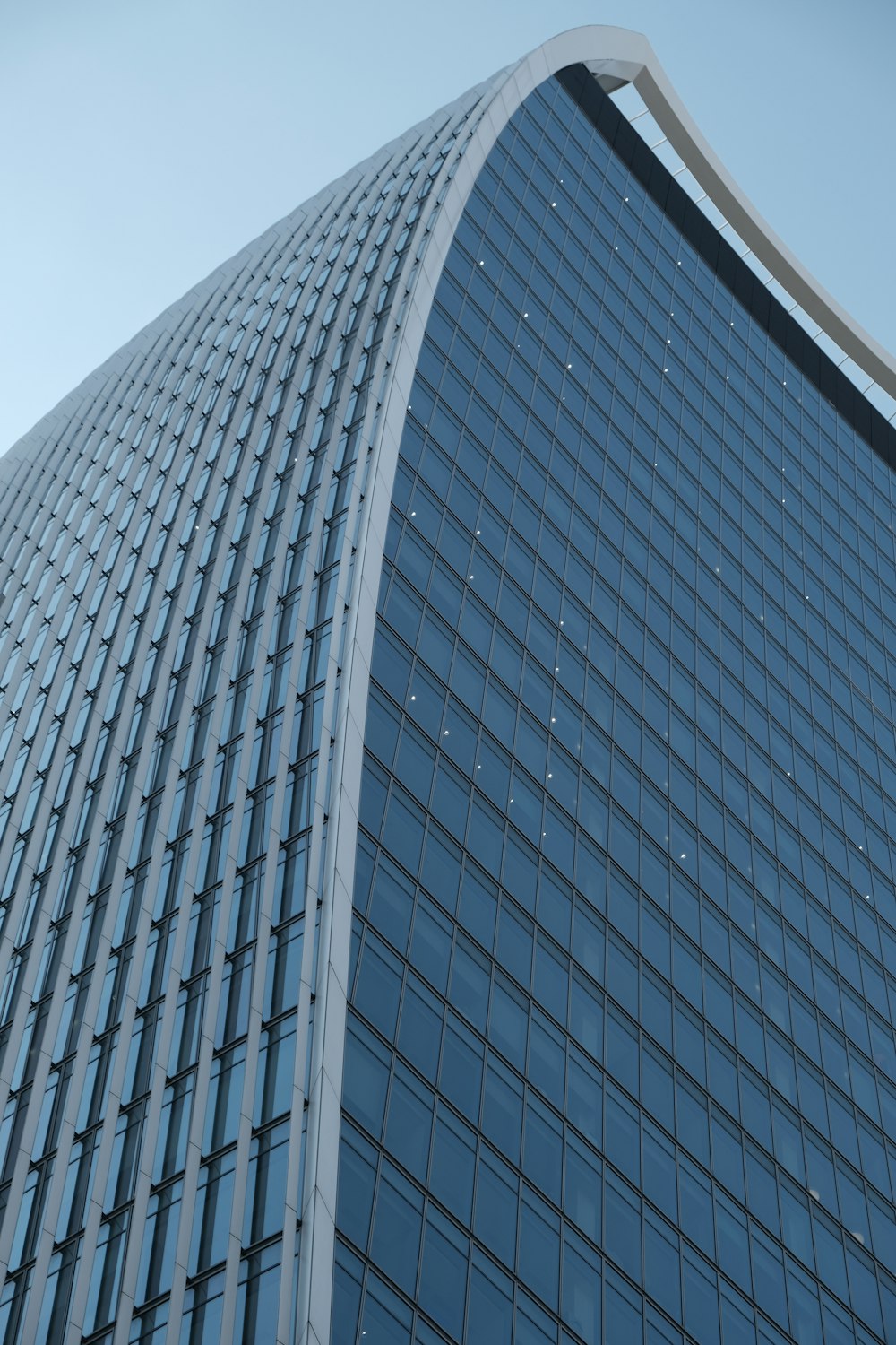 a very tall glass building with a sky in the background