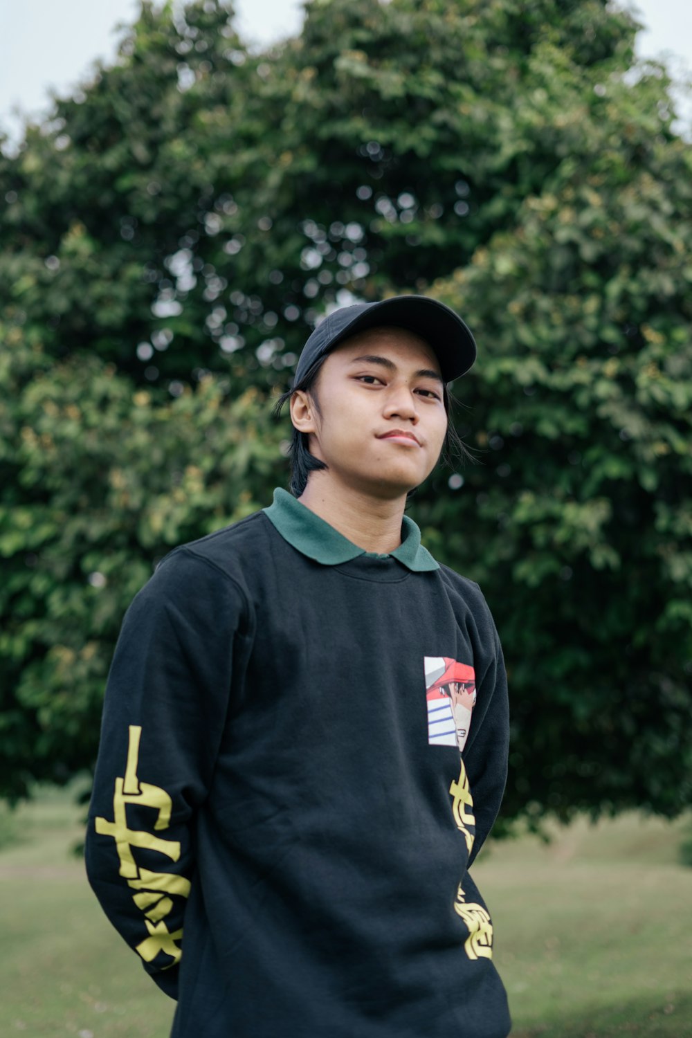 a boy in a baseball cap is standing in a field