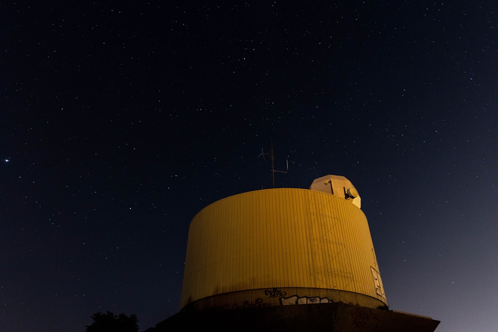 a very large yellow tower with a star in the sky