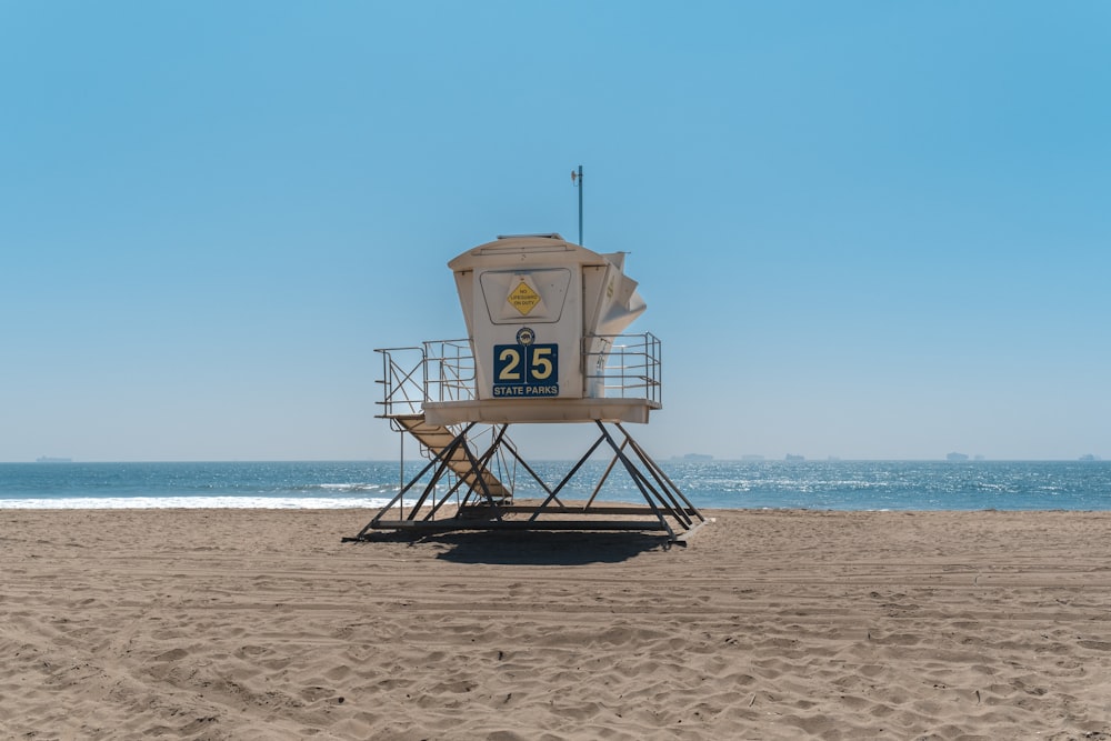 a lifeguard tower on the beach with the ocean in the background