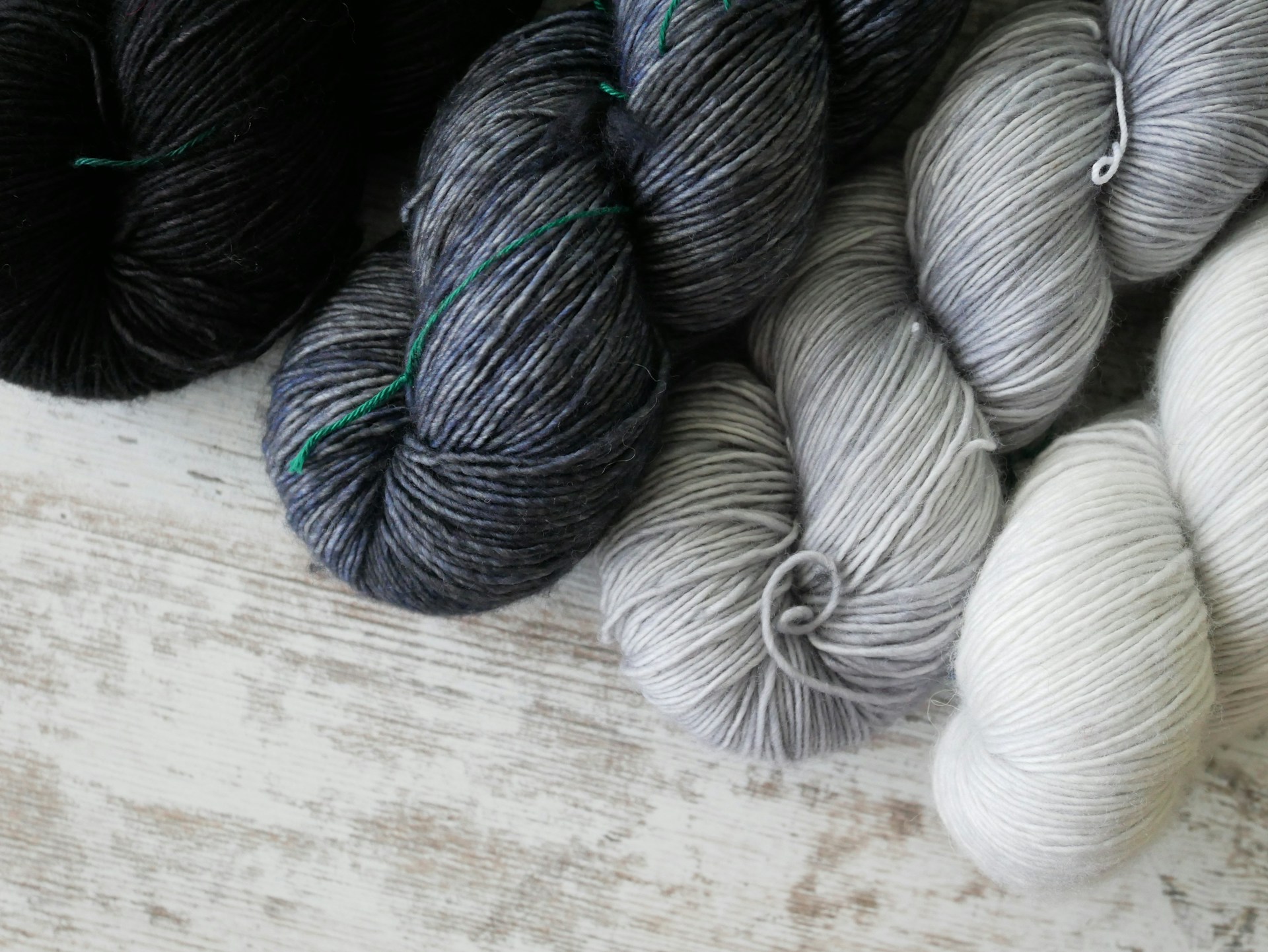 a pile of skeins of yarn sitting on top of a wooden table