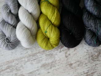 a group of skeins of yarn sitting on top of a wooden table