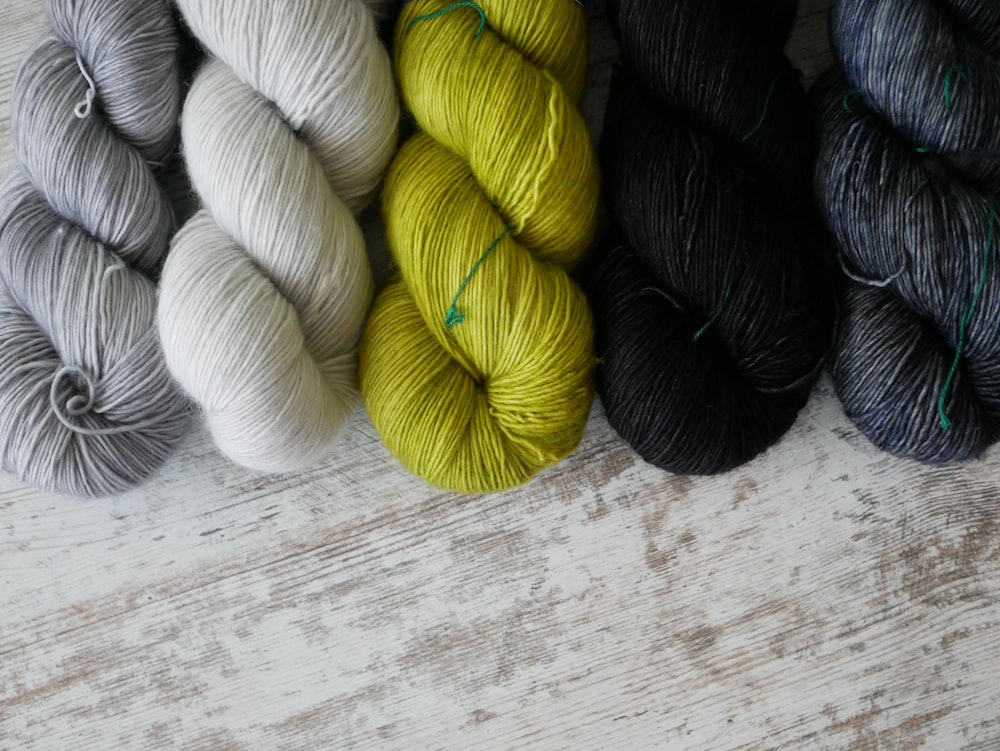 a group of skeins of yarn sitting on top of a wooden table