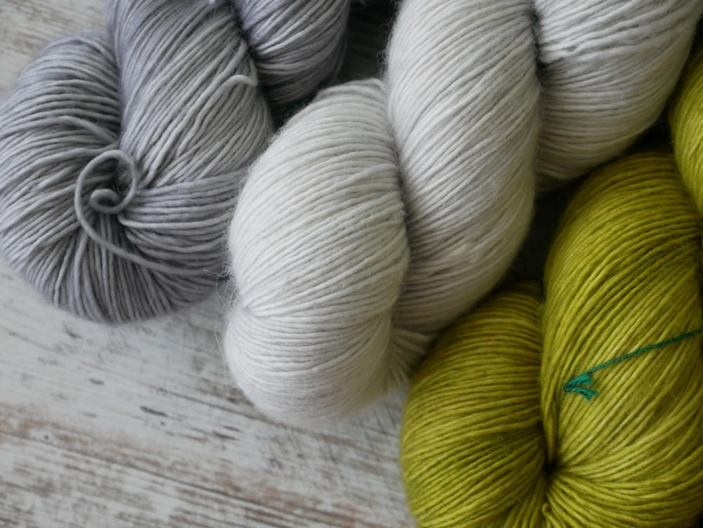 a pile of skeins of yarn sitting on top of a wooden table