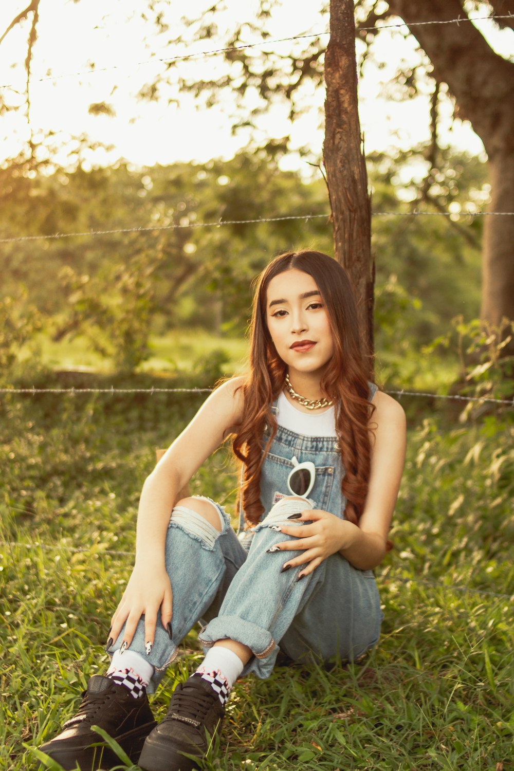 a woman sitting in the grass with a camera