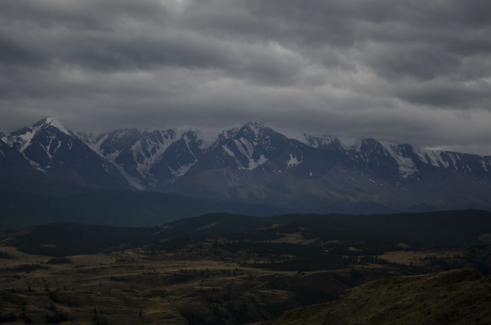 a mountain range with snow capped mountains in the distance