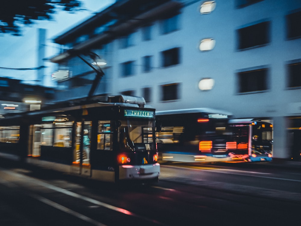 a bus driving down a street next to a tall building