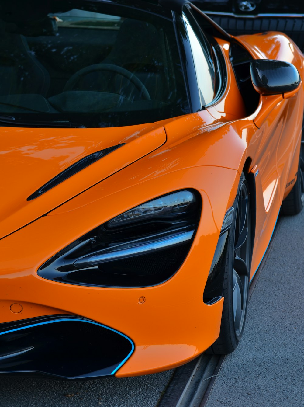 an orange sports car parked on the side of the road