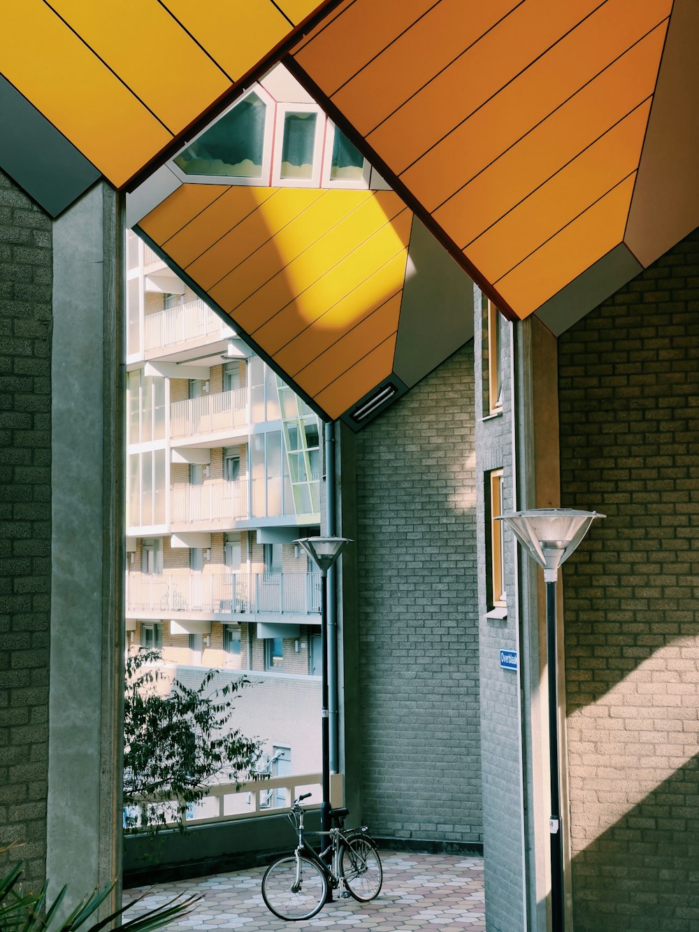 a bike parked under a yellow umbrella next to a building