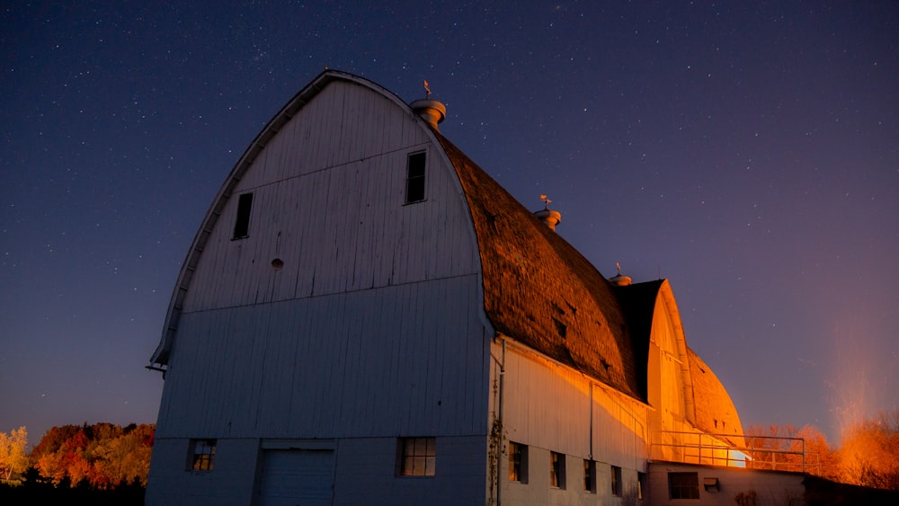 a barn with a night sky in the background