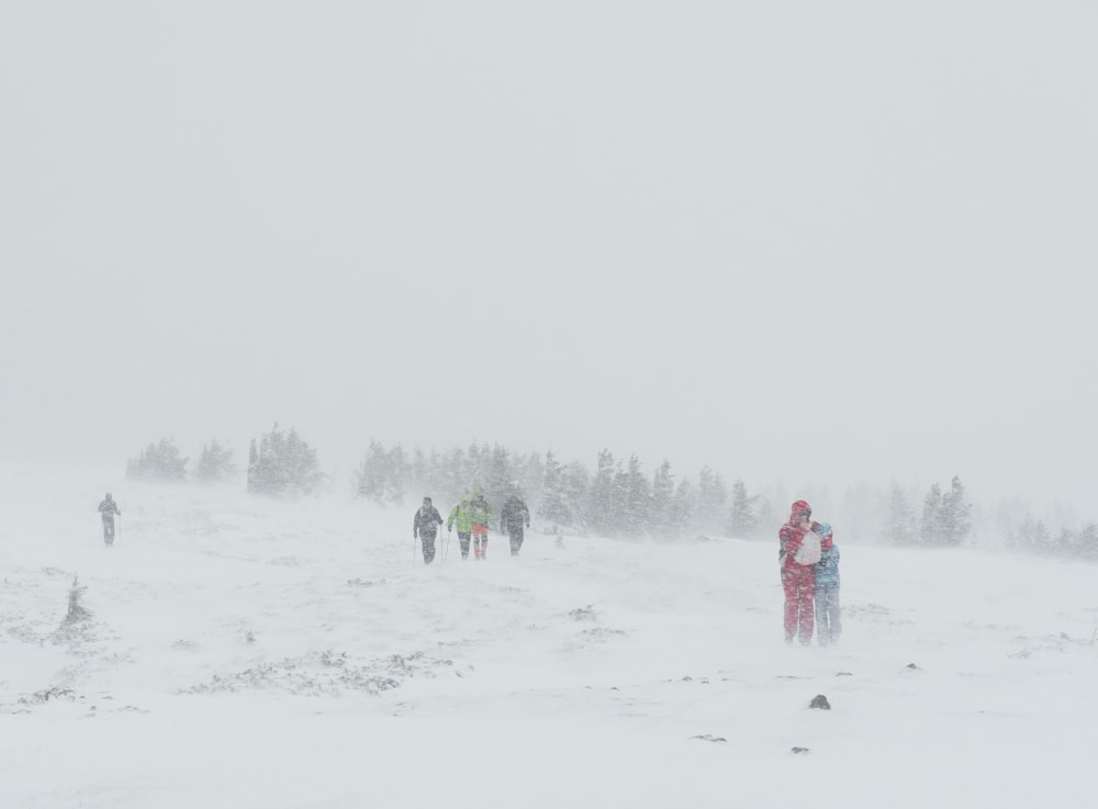 a group of people walking across a snow covered field