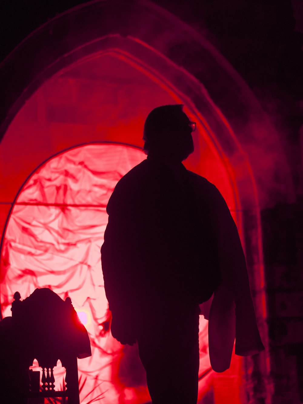 a man standing in front of a red light