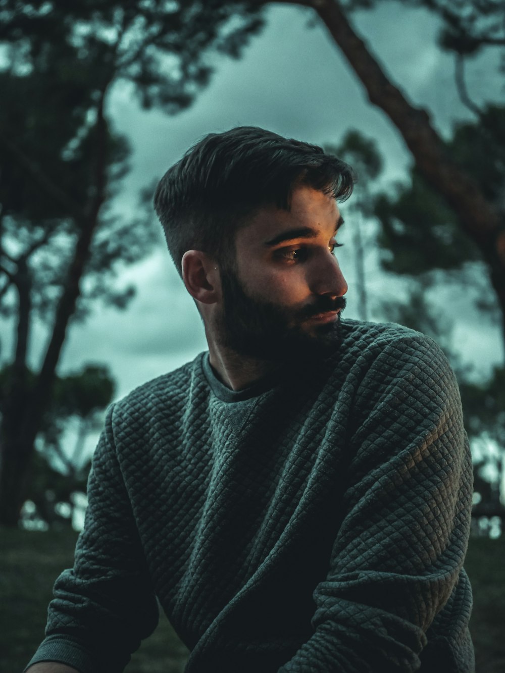 a man with a beard sitting on a bench