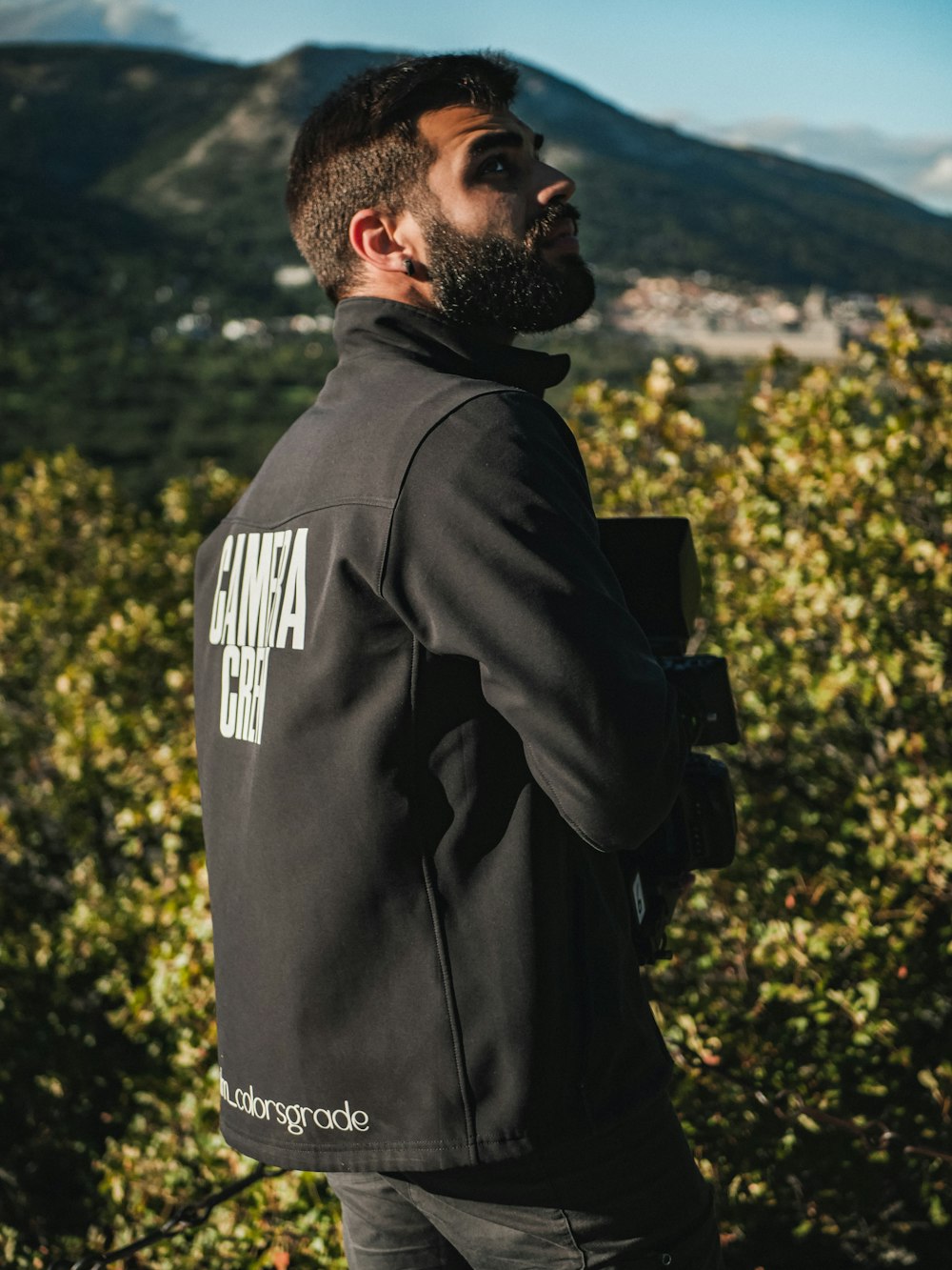 a man in a black jacket looking up into the sky