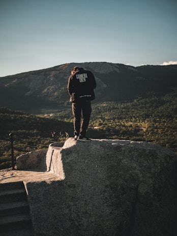 A high-contrast image of a camera crew capturing a documentary interview in a scenic mountain location.