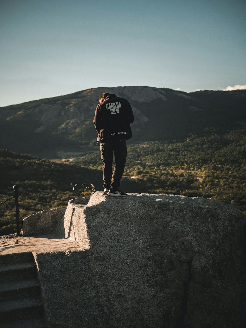 Ein Mann steht auf einem großen Felsen