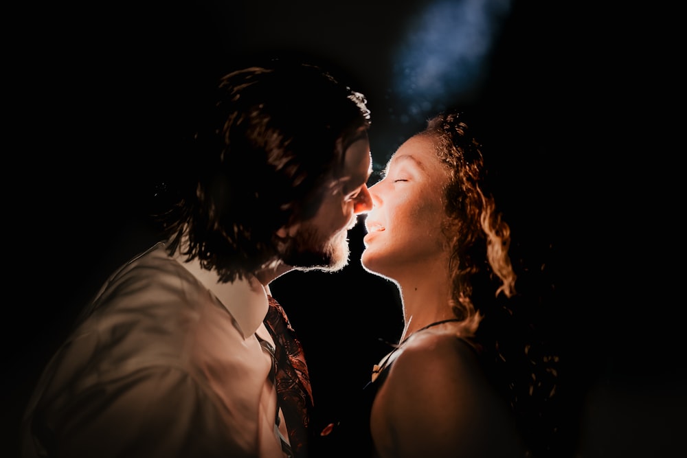 a man and a woman kissing in the dark