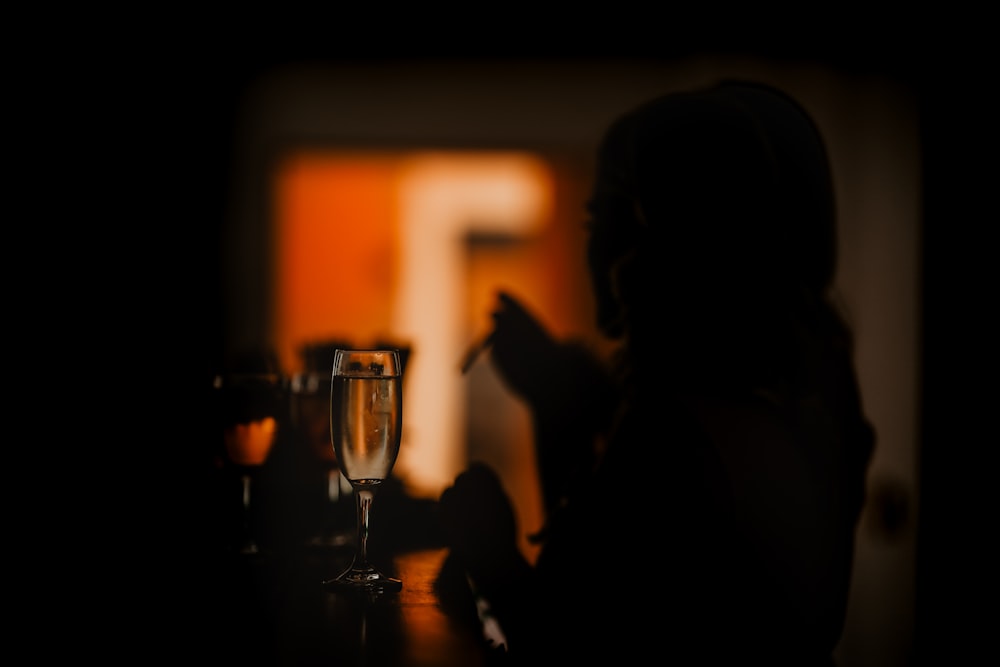 a woman sitting at a table with a glass of wine