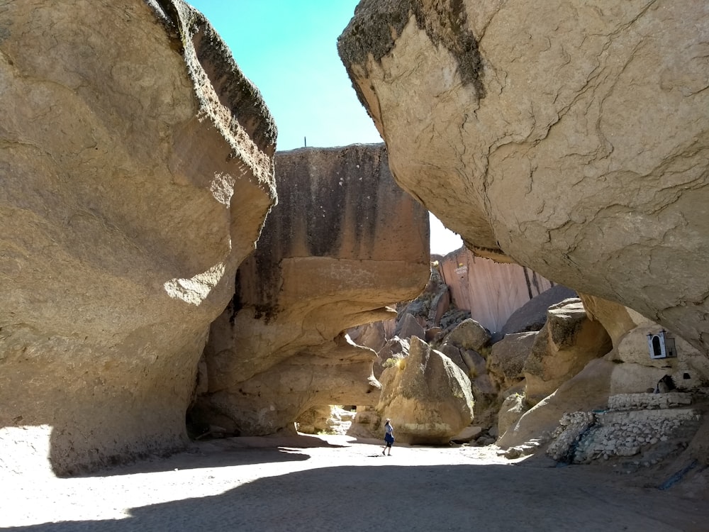 a person standing between two large rocks