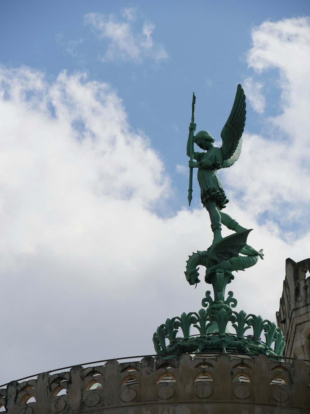 a statue on top of a building with a sky background