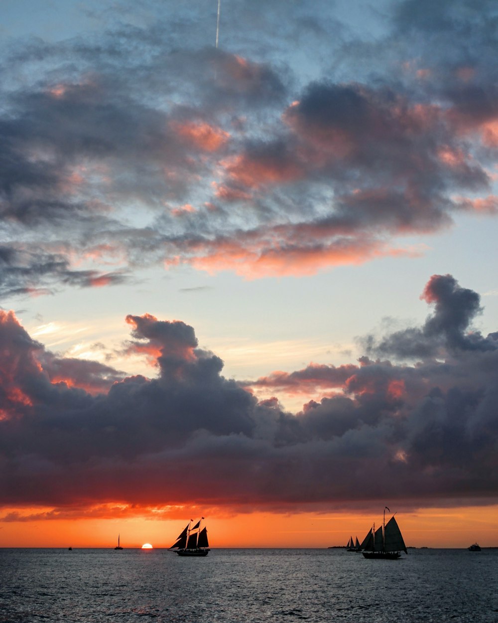 a group of sailboats floating on top of a body of water