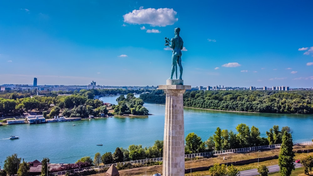 una estatua de un hombre de pie en la cima de una torre