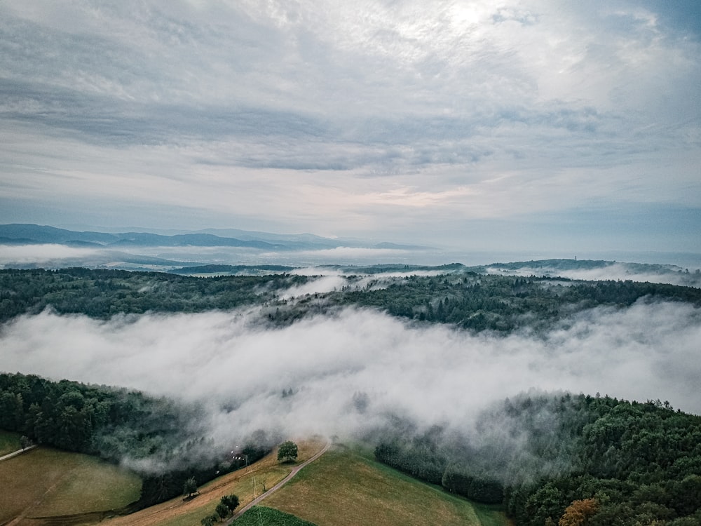 an aerial view of a valley covered in clouds