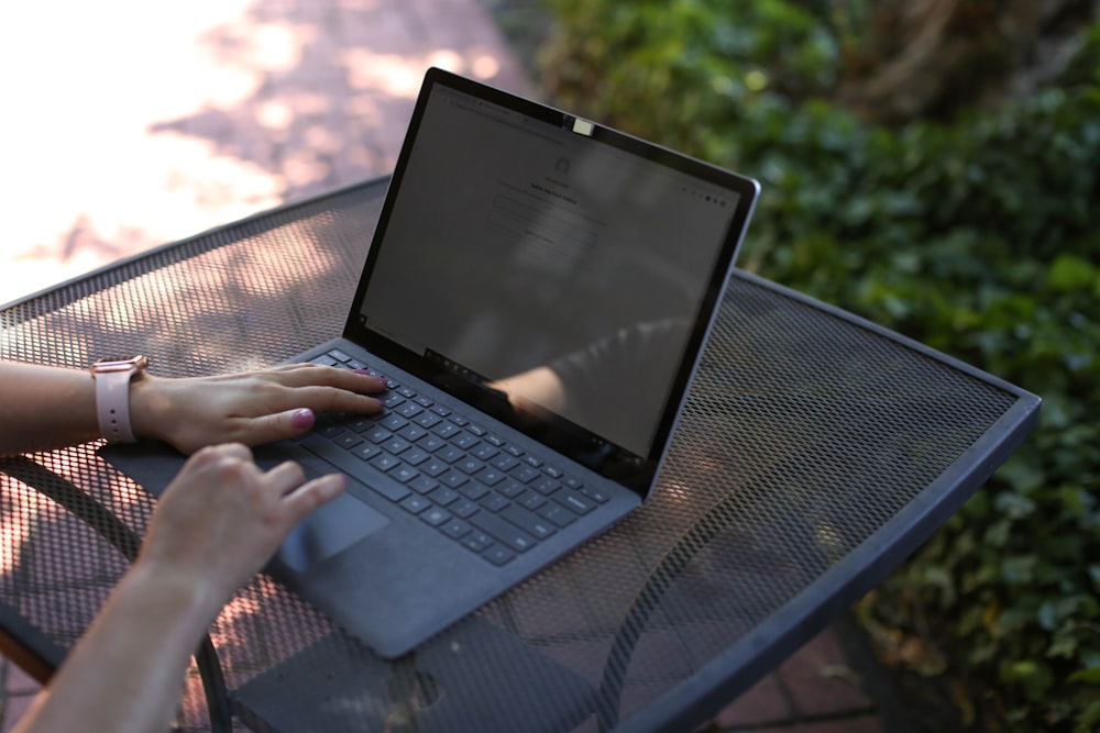 a woman sitting at a table using a laptop computer