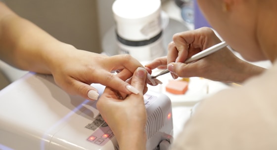 a woman getting her nails done at a nail salon