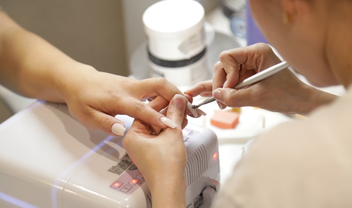 a woman getting her nails done at a nail salon